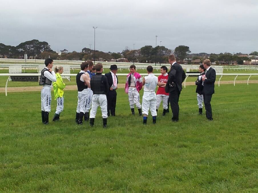 Jockeys investigate and discuss a hole on the track at Warrnambool's Oaks Day. Picture: AIDAN FAWKES