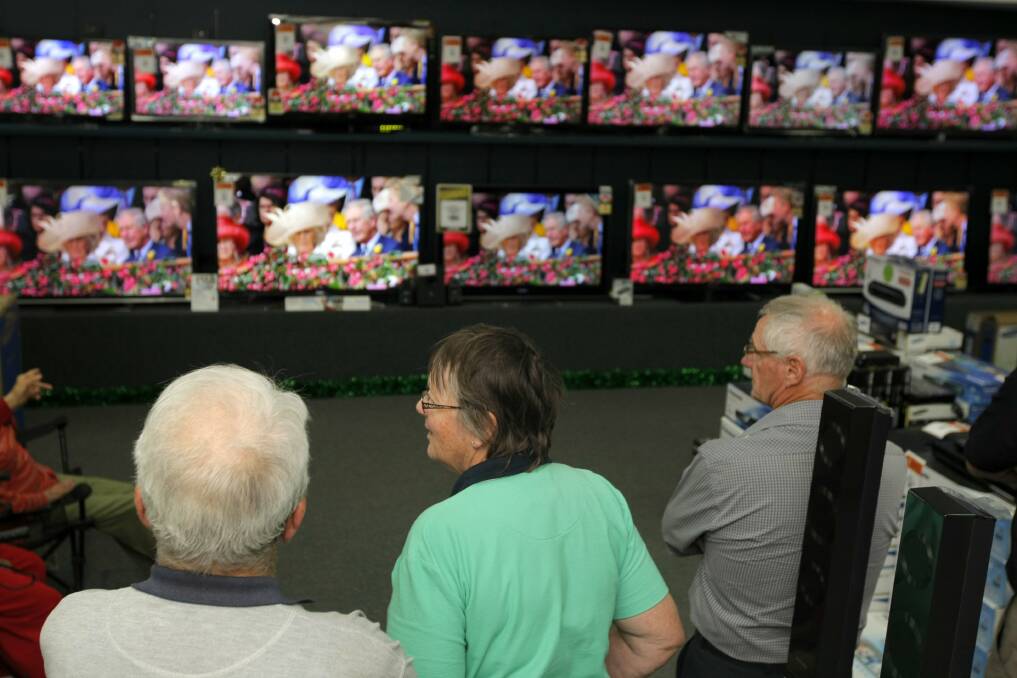 A small group of people gather at Lehy's Electricals to watch the running of the Melbourne Cup on the various screens. 