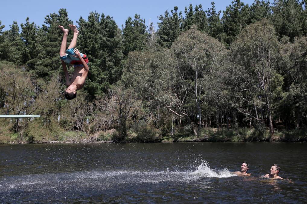 Jayden Square flips off the diving board at the Panmure Swimming Hole, as his mates Paul Croft and Allistar Bourke, 16, all of Panmure, cool off in the water. Picture: ROB GUNSTONE